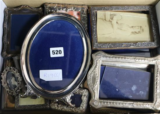 A collection of eleven silver photograph frames and one other frame.